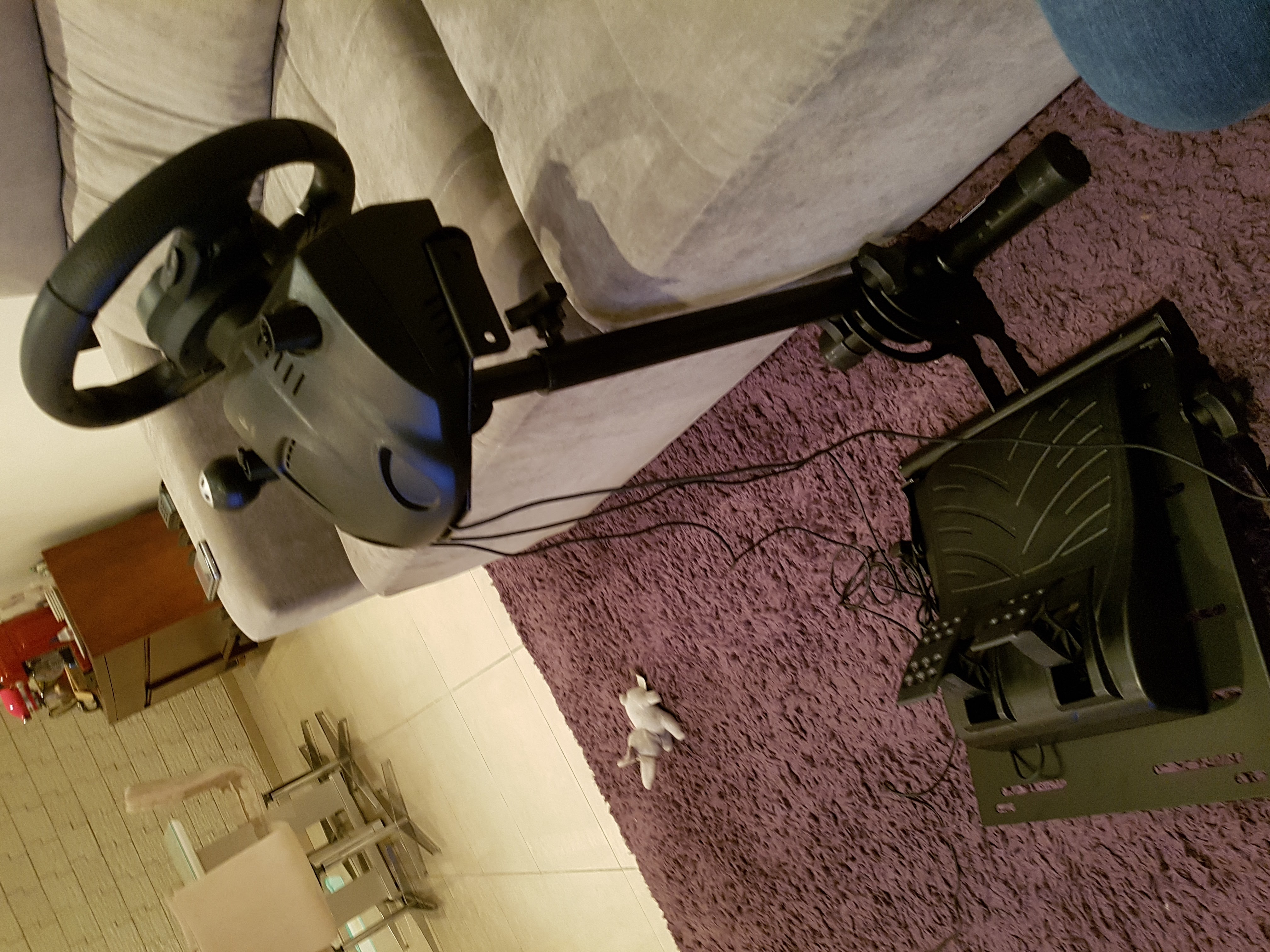 O G29 com suporte simples na frente do sofá